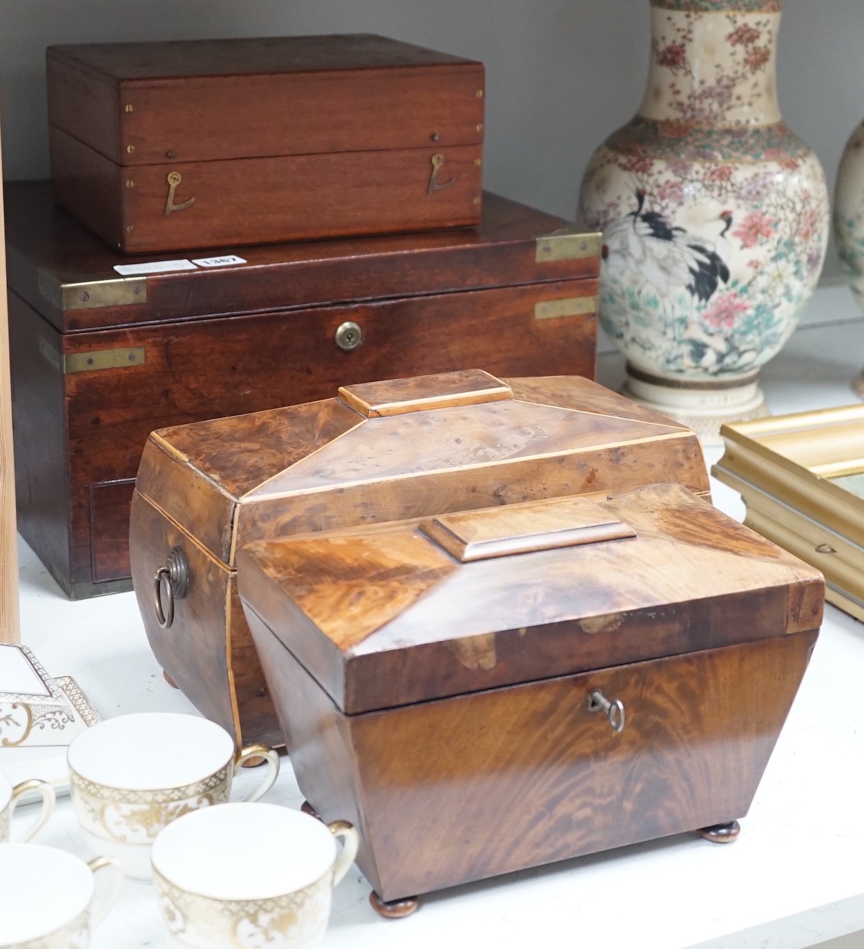 A Victorian boxwood strung burr yew sarcophagus shaped tea caddy, another mahogany tea caddy, a brass bound mahogany silver box with Bramah lock and another mahogany box. Largest 40cm wide